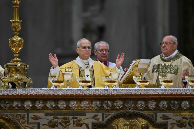 Pope Leo XIV carries out communion as he performs the Christmas Eve mass at St Peter's Basilica in the Vatican on December 24, 2025. (Photo by Andreas SOLARO / AFP)