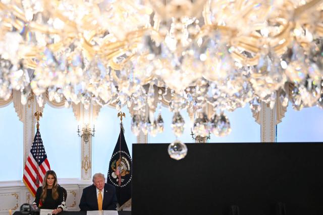 US President Donald Trump and first lady Melania Trump participate in calls to US service members, on Christmas Eve, from the Mar-a-Lago club in Palm Beach, Florida, December 24, 2025. (Photo by ANDREW CABALLERO-REYNOLDS / AFP)