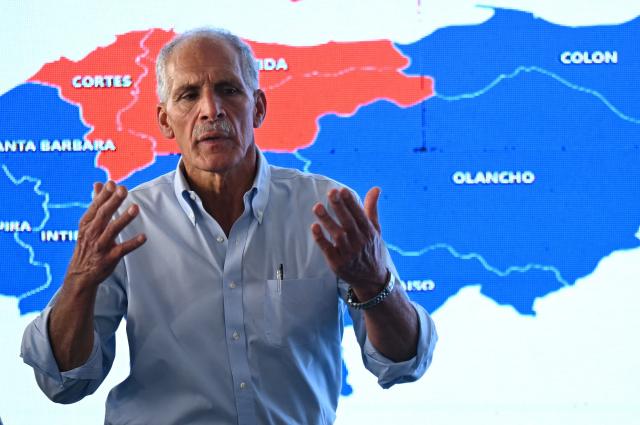 (FILES) Honduras' presidential candidate of the National Party Nasry Asfura speaks in front of a screen projecting a map of Honduras during a press conference in Tegucigalpa on December 1, 2025, a day after the presidential election. Conservative businessman Nasry Asfura, backed by US President Donald Trump, was officially proclaimed the new president of Honduras on December 24, 2025, three weeks after an election marked by a narrow margin of victory and allegations of fraud. (Photo by Marvin RECINOS / AFP)