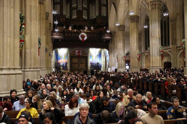 People attend a Christmas Mass at St. Patrick’s Cathedral on Christmas Eve on December 24, 2025 in New York. (Photo by ANGELA WEISS / AFP)