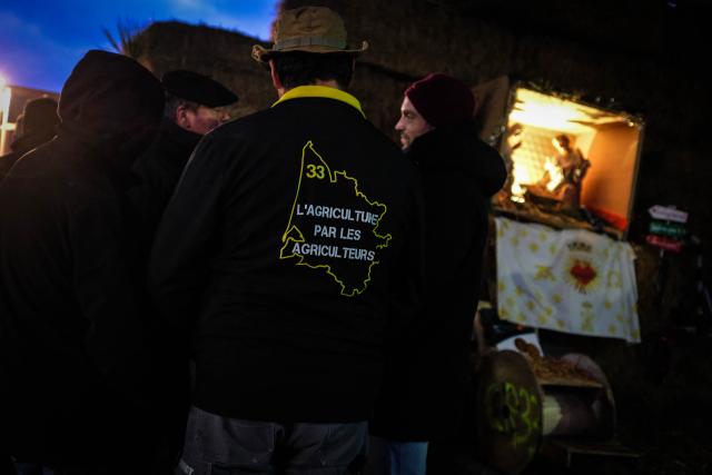 Protesters gather on Christmas eve during a road blockade on the A63 motorway amid a farmers's protest against the government's mandatory culling protocol for cattle herds affected by lumpy skin disease (dermatose nodulaire contagieuse), in Cestas, near Bordeaux, south-western France, on December 24, 2025. (Photo by Thomas BERNARDI / AFP)