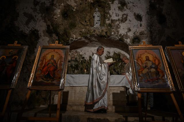 Priests celebrate the Christmas Eve mass at the Church of Saint Peter, where the first religious gathering was held in the 1st century, the birth of Christianity, on December 24, 2025 in Antakya. The first rock-cut church in Christendom, Saint Peter's now brings together the isolated Christians of Antakya, ancient Antioch, in south-eastern Turkey. Families begin on Christmas Eve to gather at the cave where Peter, the disciple of Jesus on whom he relied to found his church, held his first religious meeting in the 1st century, at the dawn of Christianity. (Photo by Ozan KOSE / AFP)