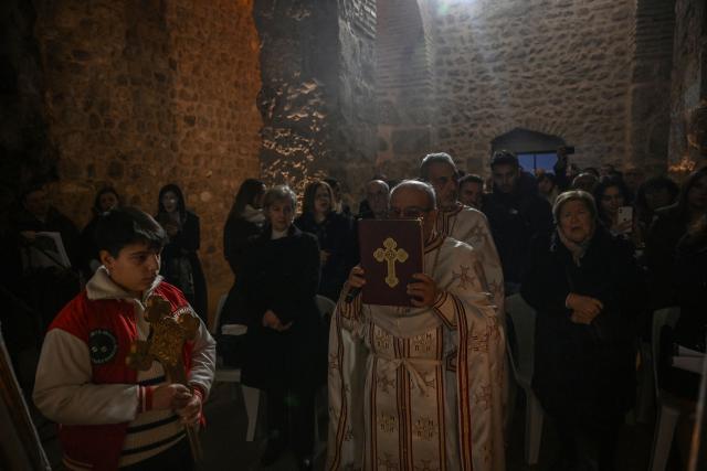 Priests celebrate the Christmas Eve mass at the Church of Saint Peter, where the first religious gathering was held in the 1st century, the birth of Christianity, on December 24, 2025 in Antakya. The first rock-cut church in Christendom, Saint Peter's now brings together the isolated Christians of Antakya, ancient Antioch, in south-eastern Turkey. Families begin on Christmas Eve to gather at the cave where Peter, the disciple of Jesus on whom he relied to found his church, held his first religious meeting in the 1st century, at the dawn of Christianity. (Photo by Ozan KOSE / AFP)