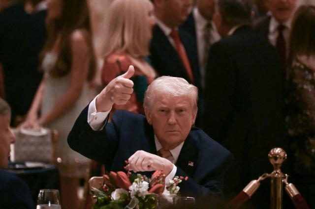 US President Donald Trump gives a thumbs up as he attends a Christmas dinner at his Mar-a-Lago resort in Palm Beach, Florida, on December 24, 2025. (Photo by ANDREW CABALLERO-REYNOLDS / AFP)