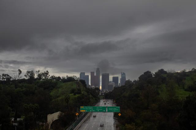 Cars drive on the 110 Freeway as heavy rain and clouds cover downtown Los Angeles on December 24, 2025. A major winter storm rolled into California on December 23, forcing hundreds of evacuations in burn areas while threatening flooding and travel delays through Christmas for much of the state, officials said.
A "strong atmospheric river brings heavy rain, snow, and wind to California through Friday," the National Weather Service said in a statement on December 23, warning anyone in northern, central and southern parts of the state to "exercise extreme caution." (Photo by Apu GOMES / AFP)