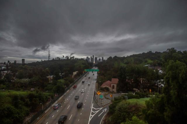 Cars drive on the 110 Freeway as heavy rain and clouds cover downtown Los Angeles on December 24, 2025. A major winter storm rolled into California on December 23, forcing hundreds of evacuations in burn areas while threatening flooding and travel delays through Christmas for much of the state, officials said.
A "strong atmospheric river brings heavy rain, snow, and wind to California through Friday," the National Weather Service said in a statement on December 23, warning anyone in northern, central and southern parts of the state to "exercise extreme caution." (Photo by Apu GOMES / AFP)