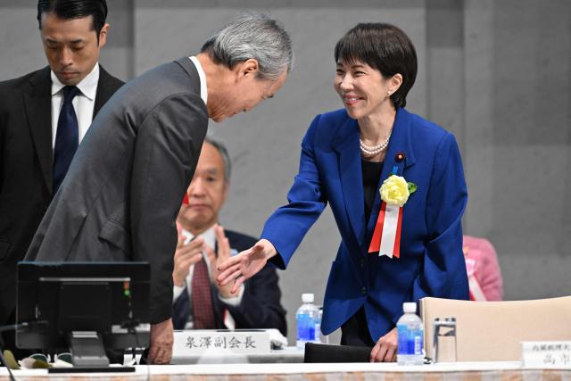 Japan's Prime Minister Sanae Takaichi is greeted by Yoshinobu Tsutsui, Chairman of the Japan Business Federation, or Keidanren, upon her arrival at the 14th Keidanren Council Meeting in Tokyo on December 25, 2025. (Photo by Kazuhiro NOGI / AFP)