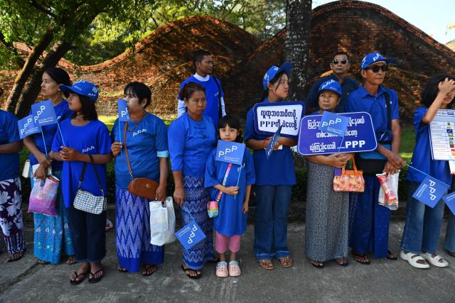 Supporters hold placards as they attend an election campaign event by Thet Thet Khine, chairperson of the People's Pioneer Party (PPP), in Yangon on December 25, 2025. (Photo by Sai Aung MAIN / AFP)