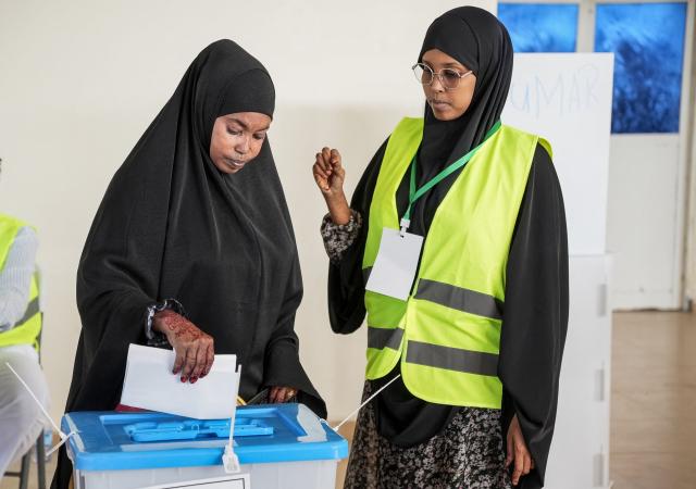 A voter casts her ballot paper at a polling station during local council elections in Mogadishu on December 25, 2025. Somalia's capital, Mogadishu, heads to the polls on December 25, 2025 for local elections, the first time in 58 years, under a complete citywide lockdown amid security concerns. (Photo by Hassan Ali ELMI / AFP)