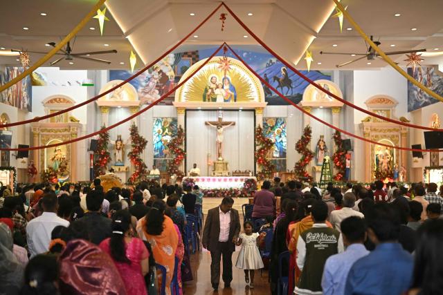 Christians attend a Christmas mass at a church in Bengaluru on December 25, 2025. (Photo by Idrees MOHAMMED / AFP)