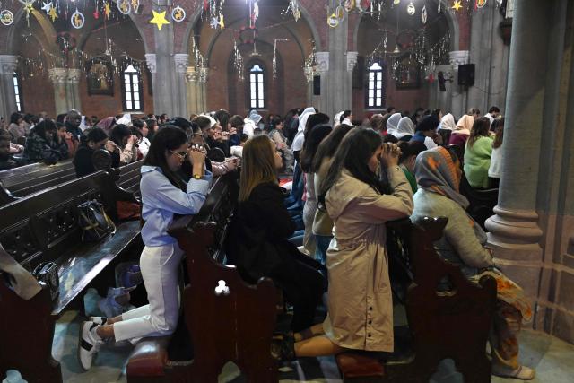 Christians pray during Christmas mass at Sacred Heart Cathedral in Lahore on December 25, 2025. (Photo by Arif ALI / AFP)