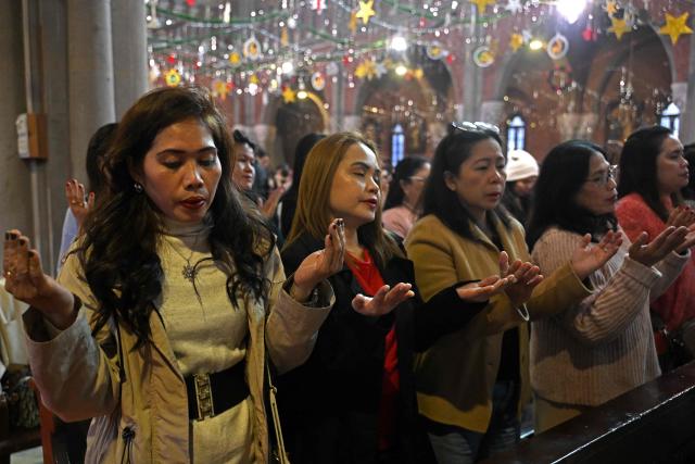Christians pray during Christmas mass at Sacred Heart Cathedral in Lahore on December 25, 2025. (Photo by Arif ALI / AFP)