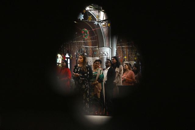 Christians pray during Christmas mass at Sacred Heart Cathedral in Lahore on December 25, 2025. (Photo by Arif ALI / AFP)