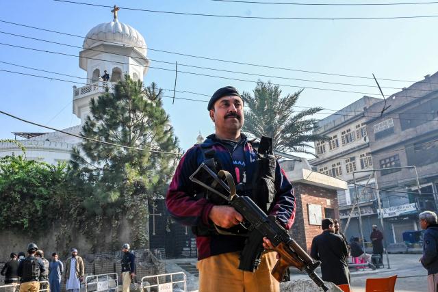Police personnel stand guard on the occasion of Christmas outside All Saints' Church in Peshawar on December 25, 2025. After passing multiple checkpoints and beneath the watch of snipers stationed overhead, hundreds of Christians gathered in northwest Pakistan on December 25 to celebrate Christmas at All Saints' Church where over 110 people were murdered by an Islamist insurgency group 12 years ago. (Photo by Abdul MAJEED / AFP)