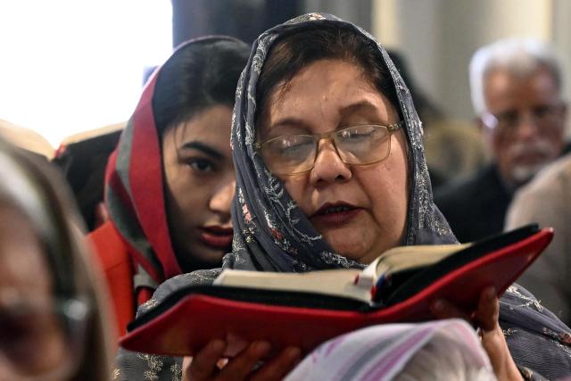 People pray on the occasion of Christmas at All Saints' Church in Peshawar on December 25, 2025. After passing multiple checkpoints and beneath the watch of snipers stationed overhead, hundreds of Christians gathered in northwest Pakistan on December 25 to celebrate Christmas at All Saints' Church where over 110 people were murdered by an Islamist insurgency group 12 years ago. (Photo by Abdul MAJEED / AFP)