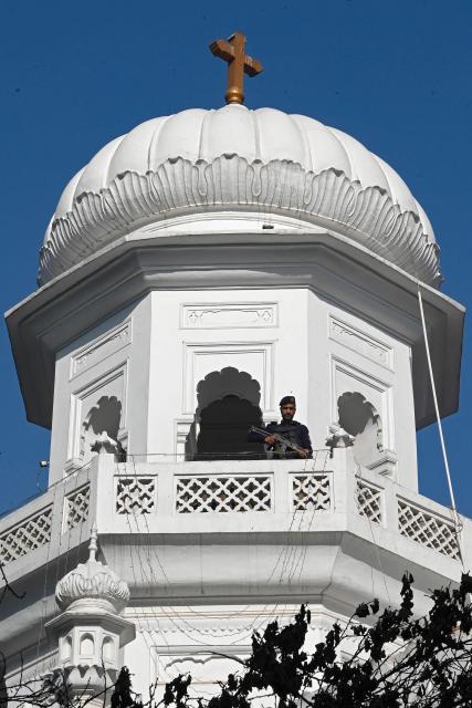 A police personnel stands guard on the occasion of Christmas at All Saints' Church in Peshawar on December 25, 2025. After passing multiple checkpoints and beneath the watch of snipers stationed overhead, hundreds of Christians gathered in northwest Pakistan on December 25 to celebrate Christmas at All Saints' Church where over 110 people were murdered by an Islamist insurgency group 12 years ago. (Photo by Abdul MAJEED / AFP)