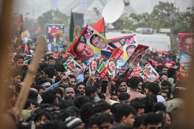 Supporters of Tarique Rahman, son of former prime minister Khaleda Zia and Bangladesh Nationalist Party (BNP)'s apparent heir hold posters with his portrait during a rally after Rahman's arrival in Dhaka on December 25, 2025. Aspiring prime minister and political heavyweight Rahman was welcomed back to Bangladesh on December 25 by huge crowds of joyous supporters after 17 years in self-imposed exile. (Photo by Munir UZ ZAMAN / AFP)