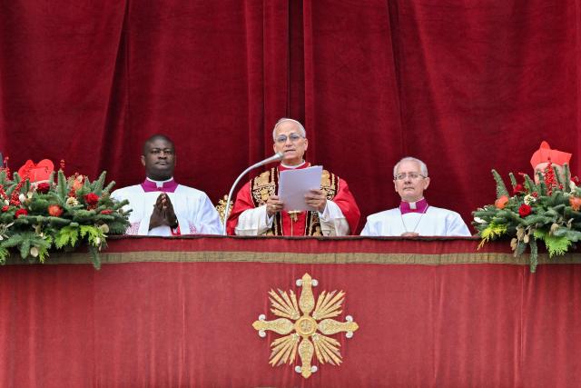 Pope Leo XIV delivers at the main balcony of St. Peter's basilica the Urbi et Orbi message and blesses to the city and the world as part of Christmas celebrations, at St Peter's square in the Vatican on December 25, 2025. (Photo by Tiziana FABI / AFP)