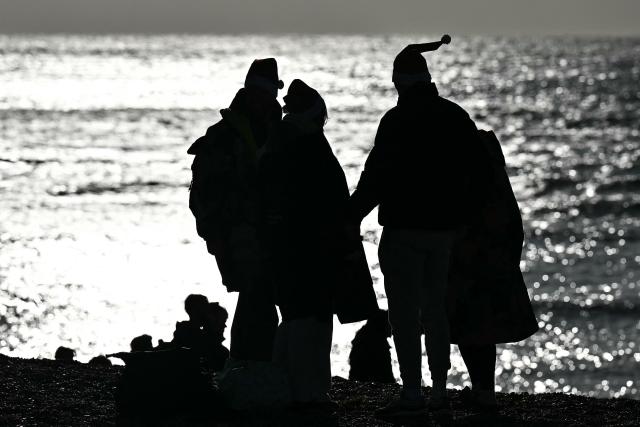Participants take part in a Christmas Day swim in the sea at Brighton beach, southern England on December 25, 2025. (Photo by Ben STANSALL / AFP)