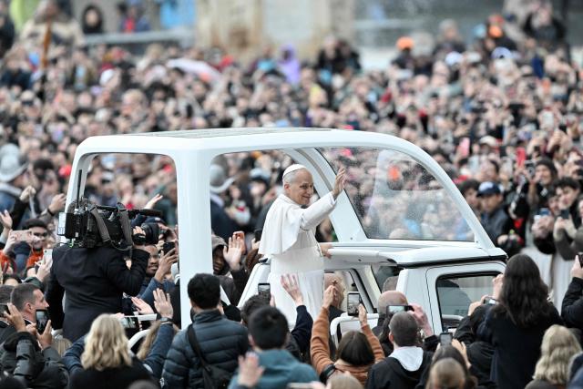 Pope Leo XIV waves to faithfull as he arrives aboard the popemobile ahead of addressing the Urbi et Orbi message and blessing to the city and the world as part of Christmas celebrations, at St Peter's square in the Vatican on December 25, 2025. (Photo by Tiziana FABI / AFP)