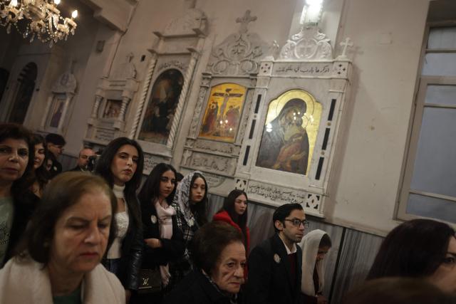 Worshippers attend Christmas celebrations at the St. George's Syriac Orthodox Church in the old city of Damascus on December 25, 2025. In early December, the Syrian president urged Syrians to work together to rebuild the country as they marked a year since the ousting of longtime ruler Bashar al-Assad. In the Old City, home to a small but vibrant Christian community and several important churches, red baubles hang from some trees, shopkeepers have put up Christmas decorations and street vendors peddle warm chestnuts. The so-called neighbourhood committees are also providing additional security, with dozens of local Christians protecting churches in coordination with government forces. (Photo by Bakr ALkasem / AFP)