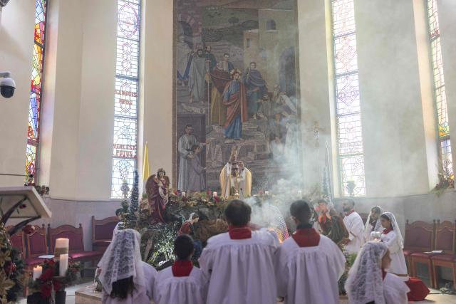 Abouna Bashar Basiel leads a Christmas morning mass at the Christ the Redeemer Church in the mostly Christian town of Taybeh, in the Israeli-occupied West Bank on December 25, 2025. (Photo by ILIA YEFIMOVICH / AFP)