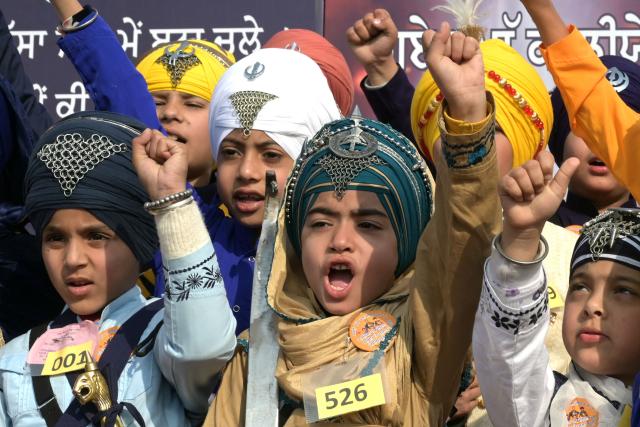 Sikh children shout slogans during a turban-tying competition commemorating the martyrdom of the sons of Sikh Guru Gobind Singh in Amritsar on December 25, 2025. (Photo by Narinder NANU / AFP)
