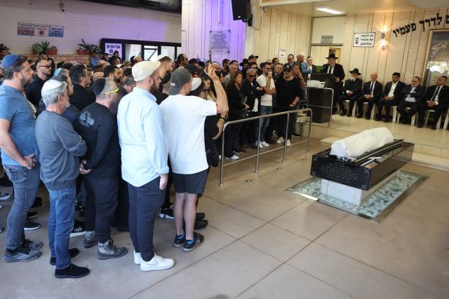 Relatives and friends of Dan Elkayam, 27, a French Jewish engineer from Le Bourget, who was killed in the terrorist attack that struck Bondi Beach in Australia on December 14, during the Jewish holiday of Hanukkah, mourn his coffin during his funeral at the Ashdod cemetery in southern Israel on December 25, 2025. Fresh details about the run-up to the Bondi killings have emerged in recent days. Police documents released December 22, said the two alleged gunmen had carried out "firearms training" in what was believed to be the New South Wales countryside. Authorities alleged the pair "meticulously planned" the attack "for many months". (Photo by Jack GUEZ / AFP)