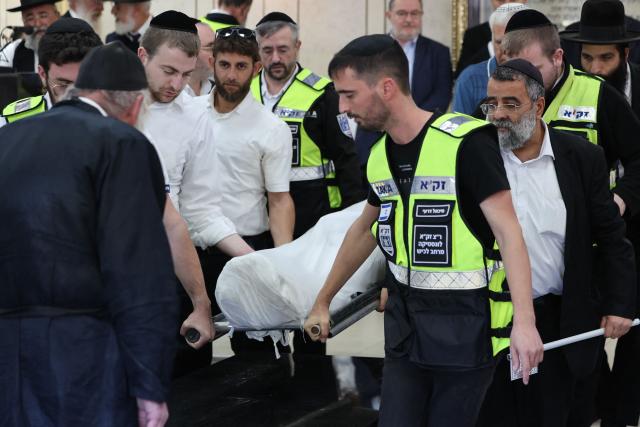 Relatives and friends of Dan Elkayam, 27, a French Jewish engineer from Le Bourget, who was killed in the terrorist attack that struck Bondi Beach in Australia on December 14, during the Jewish holiday of Hanukkah, carry his body during his funeral at the Ashdod cemetery in southern Israel on December 25, 2025. Fresh details about the run-up to the Bondi killings have emerged in recent days. Police documents released December 22, said the two alleged gunmen had carried out "firearms training" in what was believed to be the New South Wales countryside. Authorities alleged the pair "meticulously planned" the attack "for many months". (Photo by Jack GUEZ / AFP)
