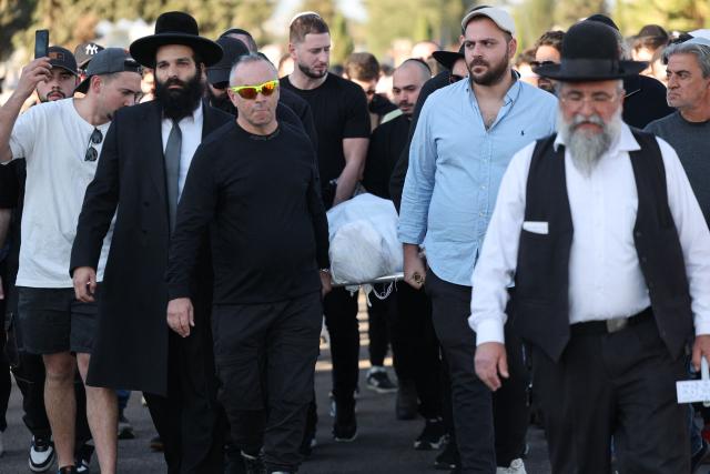 Relatives and friends of Dan Elkayam, 27, a French Jewish engineer from Le Bourget, who was killed in the terrorist attack that struck Bondi Beach in Australia on December 14, during the Jewish holiday of Hanukkah, carry his body during his funeral at the Ashdod cemetery in southern Israel on December 25, 2025. Fresh details about the run-up to the Bondi killings have emerged in recent days. Police documents released December 22, said the two alleged gunmen had carried out "firearms training" in what was believed to be the New South Wales countryside. Authorities alleged the pair "meticulously planned" the attack "for many months". (Photo by Jack GUEZ / AFP)