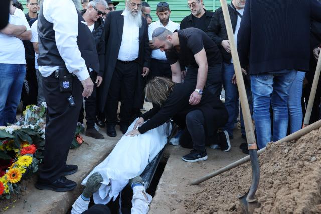 TOPSHOT - Relatives and friends of Dan Elkayam, 27, a French Jewish engineer from Le Bourget, who was killed in the terrorist attack that struck Bondi Beach in Australia on December 14, during the Jewish holiday of Hanukkah, bid farewell during his funeral at the Ashdod cemetery in southern Israel on December 25, 2025. Fresh details about the run-up to the Bondi killings have emerged in recent days. Police documents released December 22, said the two alleged gunmen had carried out "firearms training" in what was believed to be the New South Wales countryside. Authorities alleged the pair "meticulously planned" the attack "for many months". (Photo by Jack GUEZ / AFP)