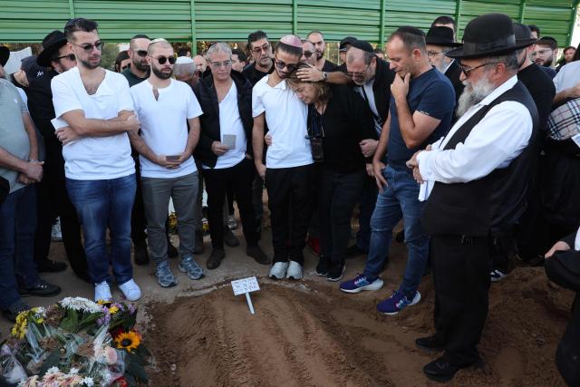 TOPSHOT - Relatives and friends of Dan Elkayam, 27, a French Jewish engineer from Le Bourget, who was killed in the terrorist attack that struck Bondi Beach in Australia on December 14, during the Jewish holiday of Hanukkah, mourn during his funeral at the Ashdod cemetery in southern Israel on December 25, 2025. Fresh details about the run-up to the Bondi killings have emerged in recent days. Police documents released December 22, said the two alleged gunmen had carried out "firearms training" in what was believed to be the New South Wales countryside. Authorities alleged the pair "meticulously planned" the attack "for many months". (Photo by Jack GUEZ / AFP)
