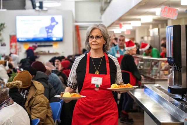 A volunteer serves meals to guests at the St. Francis House, New England’s largest day shelter, on Christmas Day in Boston, Massachusetts, on December 25, 2025. According to a 2025 census done by the city of Boston there are 2,122 single adults experience homelessness in the city. (Photo by Joseph Prezioso / AFP)
