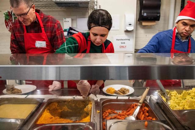 Volunteers plate meals for guests at the St. Francis House, New England’s largest day shelter, on Christmas Day in Boston, Massachusetts, on December 25, 2025. According to a 2025 census done by the city of Boston there are 2,122 single adults experience homelessness in the city. (Photo by Joseph Prezioso / AFP)