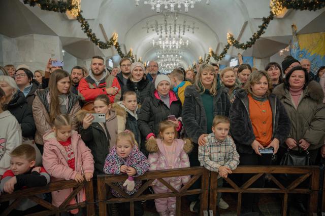 Visitors watch the folk Christmas concert "Kolyada Unites" on Christmas Day in the subway in Kharkiv on December 25, 2025, amid the Russian invasion of Ukraine. (Photo by Ivan SAMOILOV / AFP)