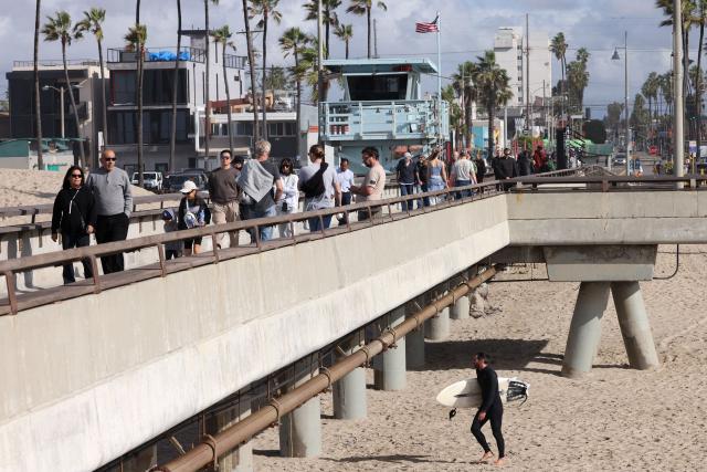Crowds of people visit the Venice Pier during a break in the rain storms affecting Southern California on December 25, 2025 in Venice, California. Torrential rains unleashed flash floods and warnings of debris flow across southern California, particularly in fire-scarred areas, with further downpours forecast for Thursday as authorities declared a state of emergency in several counties. Driven by an atmospheric river known as "the Pineapple Express," which moves heavy moisture from the tropical climes of Hawaii to the US West Coast, the storm was expected to deliver months' worth of rain over a few days. (Photo by Jonathan Alcorn / AFP)