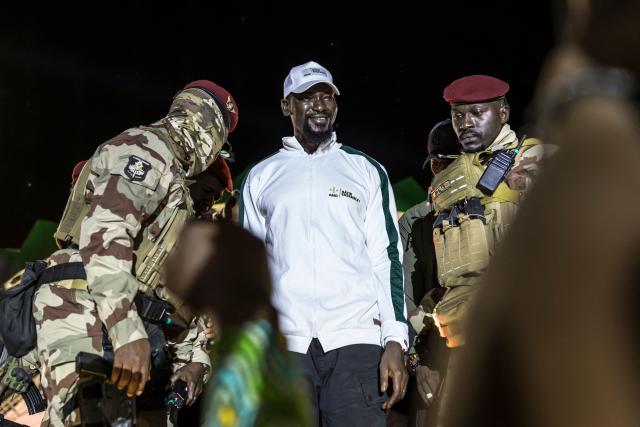 Guinea President and presidential candidate Mamady Doumbouya (C) greets supporters during his final campaign rally ahead of the country's presidential election in Conakry on December 25, 2025. Guinean voters head to the polls for a presidential election on December 28, 2025. (Photo by PATRICK MEINHARDT / AFP)