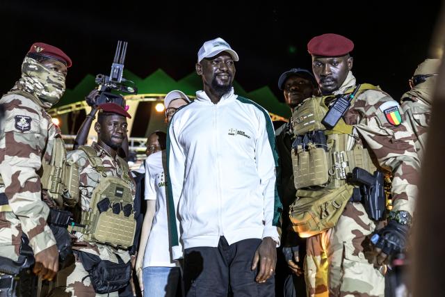Guinea President and presidential candidate Mamady Doumbouya (C) greets supporters during his final campaign rally ahead of the country's presidential election in Conakry on December 25, 2025. Guinean voters head to the polls for a presidential election on December 28, 2025. (Photo by PATRICK MEINHARDT / AFP)