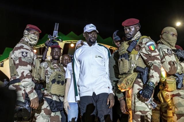 Guinea President and presidential candidate Mamady Doumbouya (C) greets supporters during his final campaign rally ahead of the country's presidential election in Conakry on December 25, 2025. Guinean voters head to the polls for a presidential election on December 28, 2025. (Photo by PATRICK MEINHARDT / AFP)