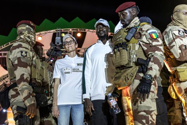 Guinea President and presidential candidate Mamady Doumbouya (C-R) greets supporters next to his wife First Lady Lauriane Doumbouya (C-L) during his final campaign rally ahead of the country's presidential election in Conakry on December 25, 2025. Guinean voters head to the polls for a presidential election on December 28, 2025. (Photo by PATRICK MEINHARDT / AFP)