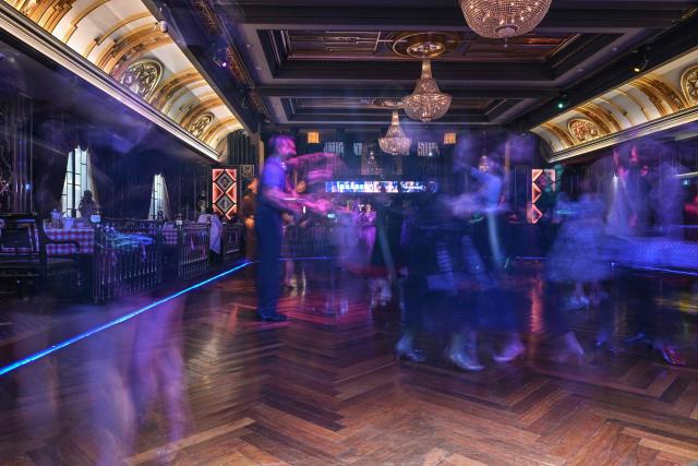 This photo taken on December 11, 2025 shows elderly guests dancing at the Paramount Ballroom in the Jing'An district of Shanghai. It was just a regular Wednesday at a lunchtime dance club in Shanghai, where dance hall culture has been deeply rooted in the city's identity since its jazz-age heyday. On any given day, multiple venues host hours-long daytime sessions across the finance hub, some starting as early as 6 am. Establishments like the historic Paramount Ballroom are time capsules from the 1930s, while others flash with neon pink and green rave lights in the early afternoon. (Photo by Hector RETAMAL / AFP) / To go with 'CHINA-LIFESTYLE-DANCE-HISTORY-DEMOGRAPHICS, REPORTAGE' by Rita QIAN