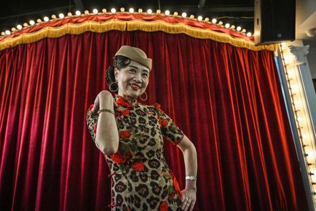 TOPSHOT - This photo taken on December 10, 2025 shows Wang Li, 65, posing for a picture at the Hai Shang Jiu Meng Dance Hall in the Changning district of Shanghai. It was just a regular Wednesday at a lunchtime dance club in Shanghai, where dance hall culture has been deeply rooted in the city's identity since its jazz-age heyday. On any given day, multiple venues host hours-long daytime sessions across the finance hub, some starting as early as 6 am. Establishments like the historic Paramount Ballroom are time capsules from the 1930s, while others flash with neon pink and green rave lights in the early afternoon. (Photo by Hector RETAMAL / AFP) / To go with 'CHINA-LIFESTYLE-DANCE-HISTORY-DEMOGRAPHICS, REPORTAGE' by Rita QIAN