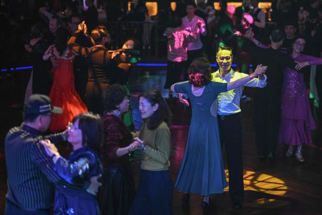 This photo taken on December 11, 2025 shows elderly guests dancing at the Paramount Ballroom in the Jing'An district of Shanghai. It was just a regular Wednesday at a lunchtime dance club in Shanghai, where dance hall culture has been deeply rooted in the city's identity since its jazz-age heyday. On any given day, multiple venues host hours-long daytime sessions across the finance hub, some starting as early as 6 am. Establishments like the historic Paramount Ballroom are time capsules from the 1930s, while others flash with neon pink and green rave lights in the early afternoon. (Photo by Hector RETAMAL / AFP) / To go with 'CHINA-LIFESTYLE-DANCE-HISTORY-DEMOGRAPHICS, REPORTAGE' by Rita QIAN