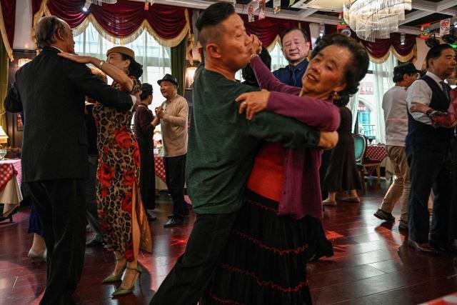 This photo taken on December 10, 2025 shows elderly guests dancing at the Hai Shang Jiu Meng Dance Hall in the Changning district of Shanghai. It was just a regular Wednesday at a lunchtime dance club in Shanghai, where dance hall culture has been deeply rooted in the city's identity since its jazz-age heyday. On any given day, multiple venues host hours-long daytime sessions across the finance hub, some starting as early as 6 am. Establishments like the historic Paramount Ballroom are time capsules from the 1930s, while others flash with neon pink and green rave lights in the early afternoon. (Photo by Hector RETAMAL / AFP) / To go with 'CHINA-LIFESTYLE-DANCE-HISTORY-DEMOGRAPHICS, REPORTAGE' by Rita QIAN