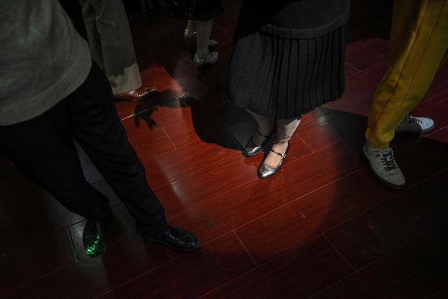 This photo taken on December 10, 2025 shows elderly guests dancing at the Hai Shang Jiu Meng Dance Hall in the Changning district of Shanghai. It was just a regular Wednesday at a lunchtime dance club in Shanghai, where dance hall culture has been deeply rooted in the city's identity since its jazz-age heyday. On any given day, multiple venues host hours-long daytime sessions across the finance hub, some starting as early as 6 am. Establishments like the historic Paramount Ballroom are time capsules from the 1930s, while others flash with neon pink and green rave lights in the early afternoon. (Photo by Hector RETAMAL / AFP) / To go with 'CHINA-LIFESTYLE-DANCE-HISTORY-DEMOGRAPHICS, REPORTAGE' by Rita QIAN