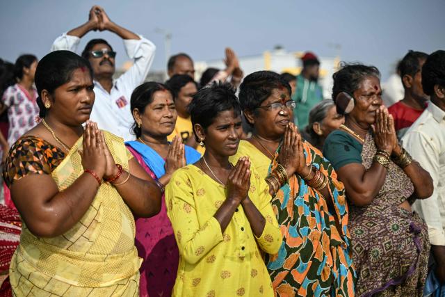 People gather to pray for the victims of the 2004 Indian Ocean tsunami during a ceremony at the Pattinapakkam beach in Chennai on December 26, 2025. (Photo by R.Satish BABU / AFP)