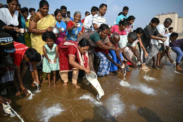 People pour milk and perform rituals to pray for the victims of the 2004 Indian Ocean tsunami during a ceremony at the Pattinapakkam beach in Chennai on December 26, 2025. (Photo by R.Satish BABU / AFP)