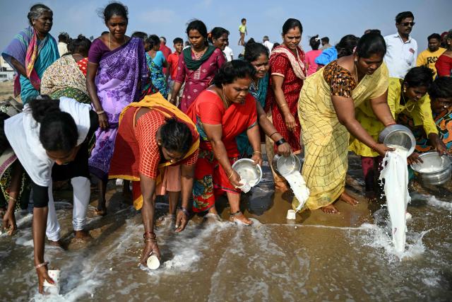 People pour milk and perform rituals to pray for the victims of the 2004 Indian Ocean tsunami during a ceremony at the Pattinapakkam beach in Chennai on December 26, 2025. (Photo by R.Satish BABU / AFP)
