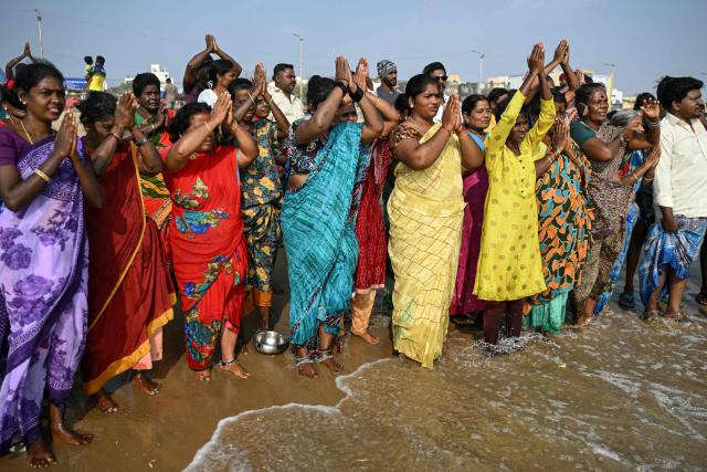 People gather to pray for the victims of the 2004 Indian Ocean tsunami during a ceremony at the Pattinapakkam beach in Chennai on December 26, 2025. (Photo by R.Satish BABU / AFP)