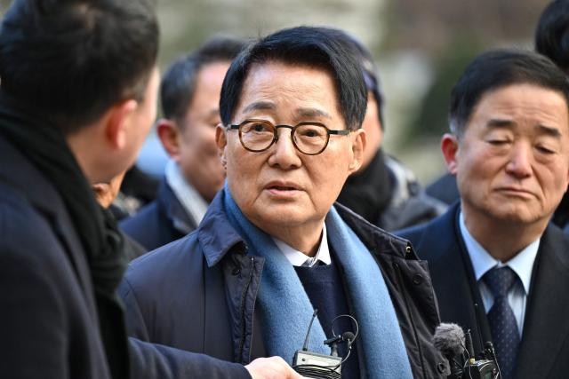 Park Jie-won (C), former spy agency chief under ex-president Moon Jae-in, speaks to reporters as he arrives to attend a trial related to the killing of a fisheries official near the inter-Korean sea border in 2020, at the Seoul Central District Court in Seoul on December 26, 2025. A South Korean court acquitted on December 26, a former top security adviser and other senior officials over the alleged cover-up of the 2020 killing of a fisheries official by Pyongyang. (Photo by Jung Yeon-je / AFP)